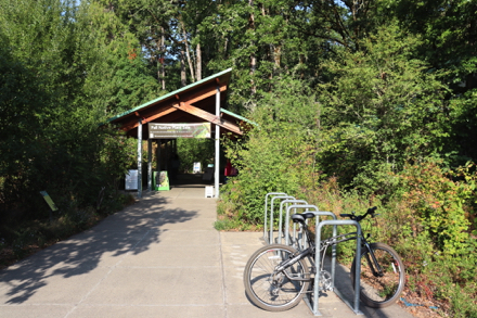 Bike rack at entrance leading to trailhead - Nature Center with restrooms on left – restrooms in building on right